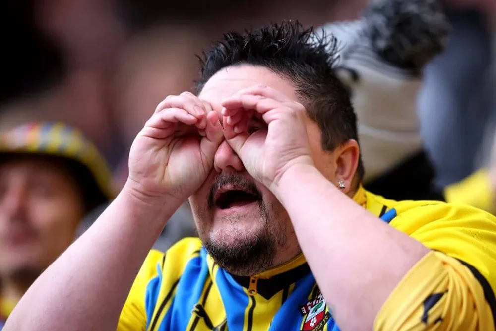 A Southampton fans pretends to use binoculars ahead of the first leg of the play-off semi-finals on Saturday